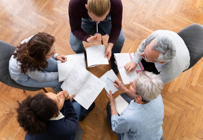 Des professionnels de santé assis en cercle qui échangent dans une posture d'écoute et de coopération - Mieux travailler ensemble avec IN FINE COACHING