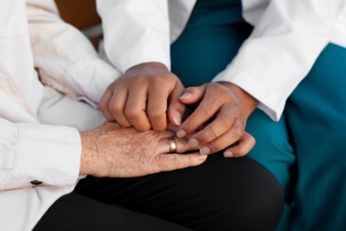 Deux mains féminines qui se serrent en gros plan, symbole d'accompagnement et de bienveillance - Accompagner les équipes santé et social avec IN FINE COACHING